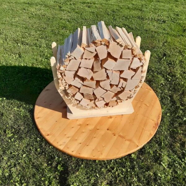 Ein Holzbund von Brennholz und Anfeuerholz von Huser Handwerk aus Urswil ist in einem Halter rund aufgetürmt
