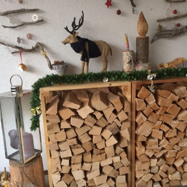 Zwei schön dekorierte Ster Rahmen mit Schweizer Brennholz aus dem Seetal vor einem Haus
