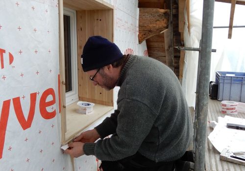 Wädi von Huser Handwerk macht einen Fenstereinbau auf einem Gerüst